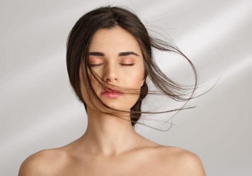 Closeup of beautiful naked woman after spa procedures enjoying herself. Eyes closed. Skin care.