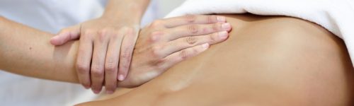 Hands massaging female abdomen.Therapist applying pressure on belly. Woman receiving massage at spa salon