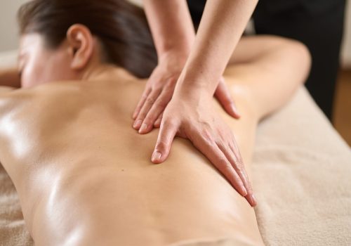 Woman receiving back massage at beauty salon